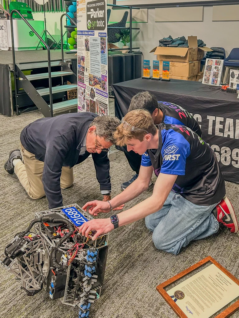Jason Bottino showing a FIRST Tech Challenge robot to Symbotic founder Rick Cohen